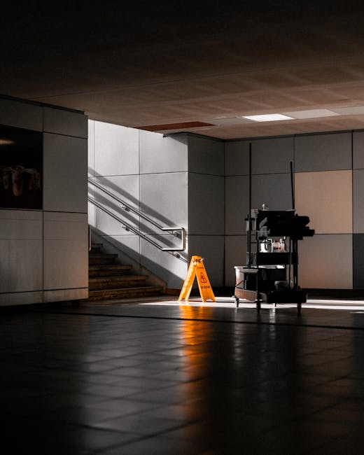 A team of three professional domestic cleaners from Cleaners Docklands is engaged in surface cleaning and deep cleaning of a modern living room. They are dressed in matching uniforms, with one holding